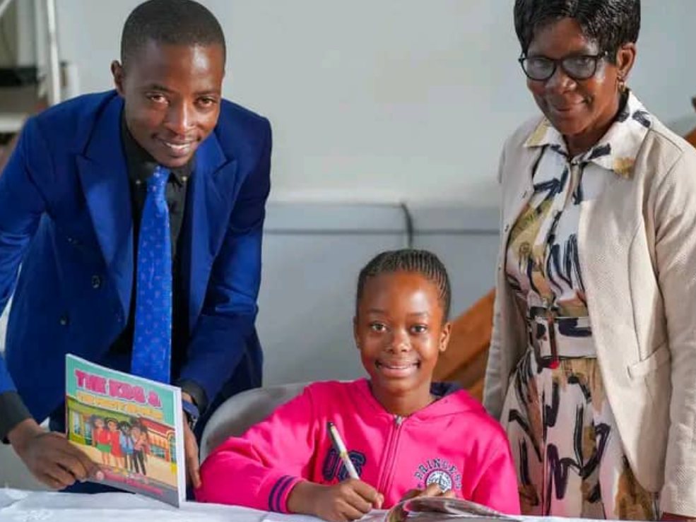 Watida Marongwe signing copies of her book at her school launch, alongside Fungayi Antony Sox.