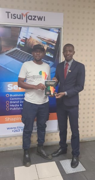 A TisuMazwi team member handing a finished book to a client at the studio.