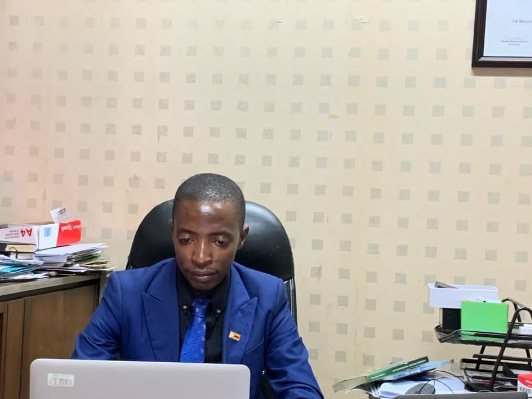 Reviewing printed proofs and copy at the TisuMazwi desk.