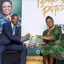 A copy of Entrepreneurial Success being handed to Dr Divine Simbi-Ndhlukula on stage at her launch.