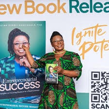 Dr Divine Simbi-Ndhlukula holding her book Entrepreneurial Success at its launch.