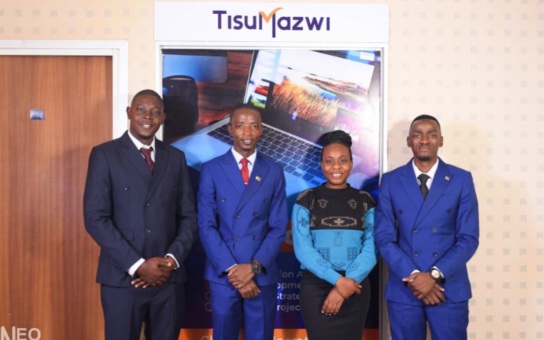 The four-member TisuMazwi team photographed together in front of the TisuMazwi banner.
