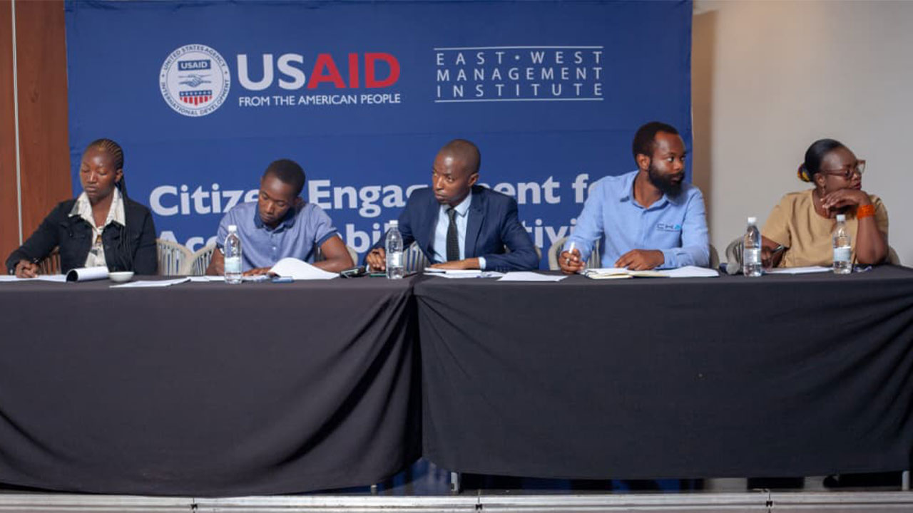 Adjudicators taking notes at the USAID and East West Management Institute youth pitch competition.